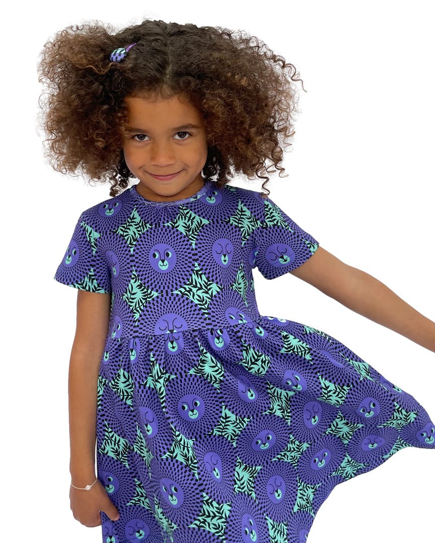 Girl wearing vibrant green/purple African inspired lion face kids dress