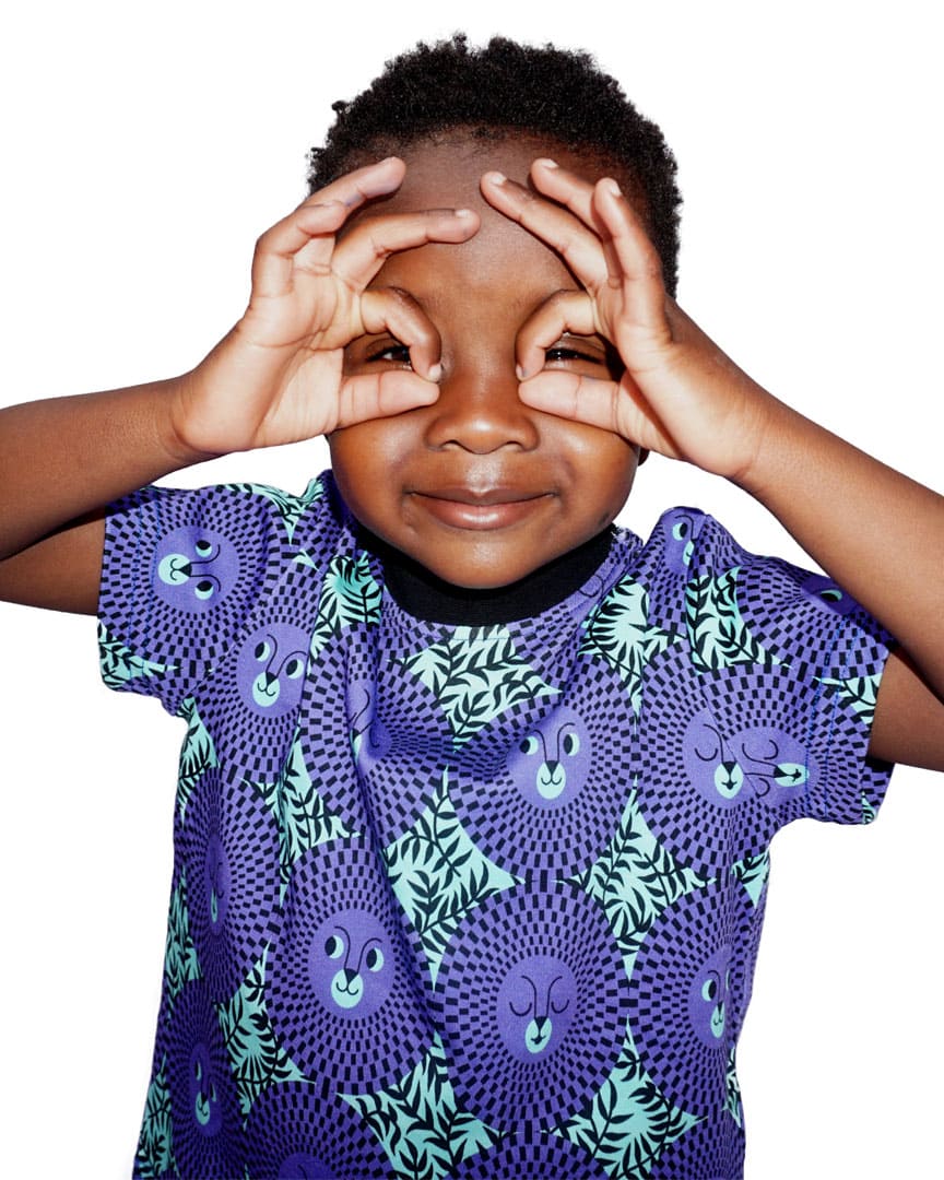 Little boy wearing vibrant green/purple African inspired lion face t-shirt